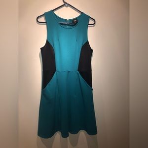 Fit and flair, torquise dress with black cutouts/pockets.